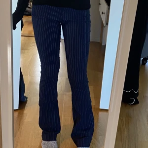 Randiga byxor  - Marinblå tajta kostymbyxor med tunna vita ränder. Bra skick och praktiska. De sitter snyggt på benen och snygga att styla med exempelvis tjocktröjor🌟Väldigt bekväma