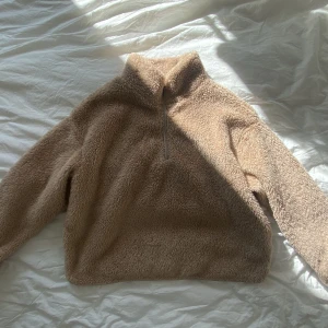 Brun Teddytröja  - Ljusbrun teddytröja med krage och dragkedja. Oanvänd. Bra skick. Lite oversize men inte för lång. 
