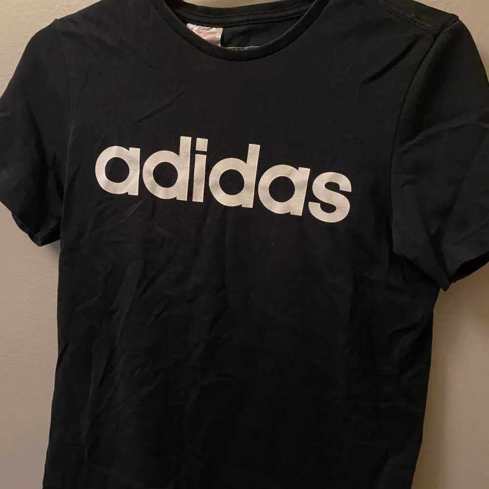 Svart Adidas t-shirt som knappt är använd. Trycket är som nytt. 🖤 Barnstorlek, men är som en xs. . T-shirts.