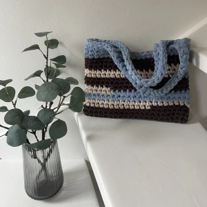 Virkad väska - Virkad väska i återvunnet bomullsmaterial från textilindustrin. 29x19cm. Använd några gånger, därav några fläckar på insidan.