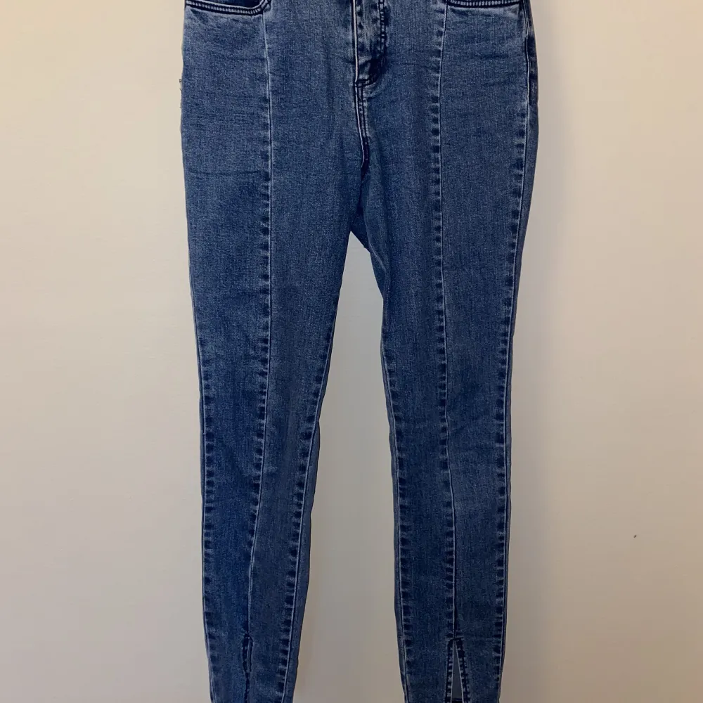 Säljer mina blåa jeans med slit i mitten av benen nertill.  Superfin blå färg 💙 Från NA-KD. Jeans & Byxor.
