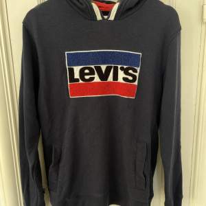 Marinblå hoodie från Levi’s med logga fram. Storlek 16. 