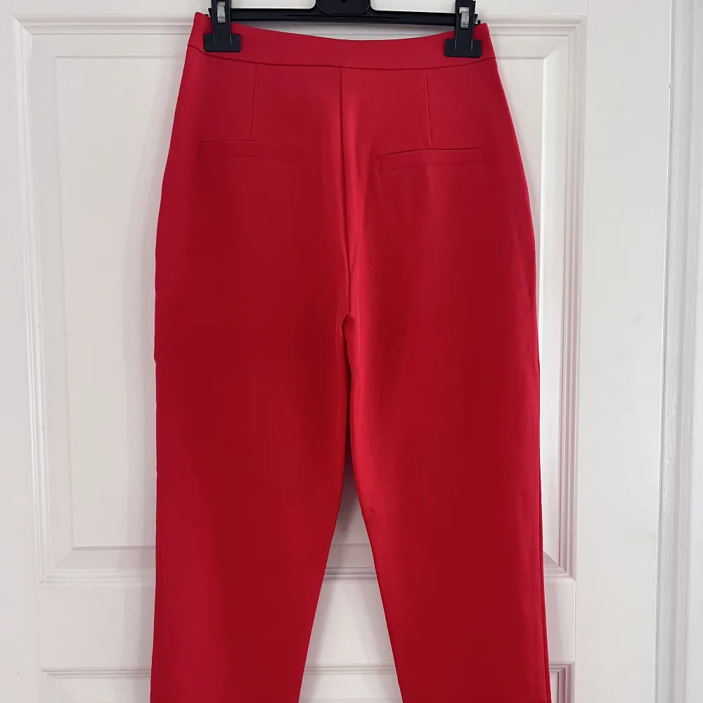 Röda kostymbyxor från Nakd. Endast använda ett fåtal gånger och är fortfarande i väldigt fint skick!!  Midjemått: ca 70 cm. Jeans & Byxor.