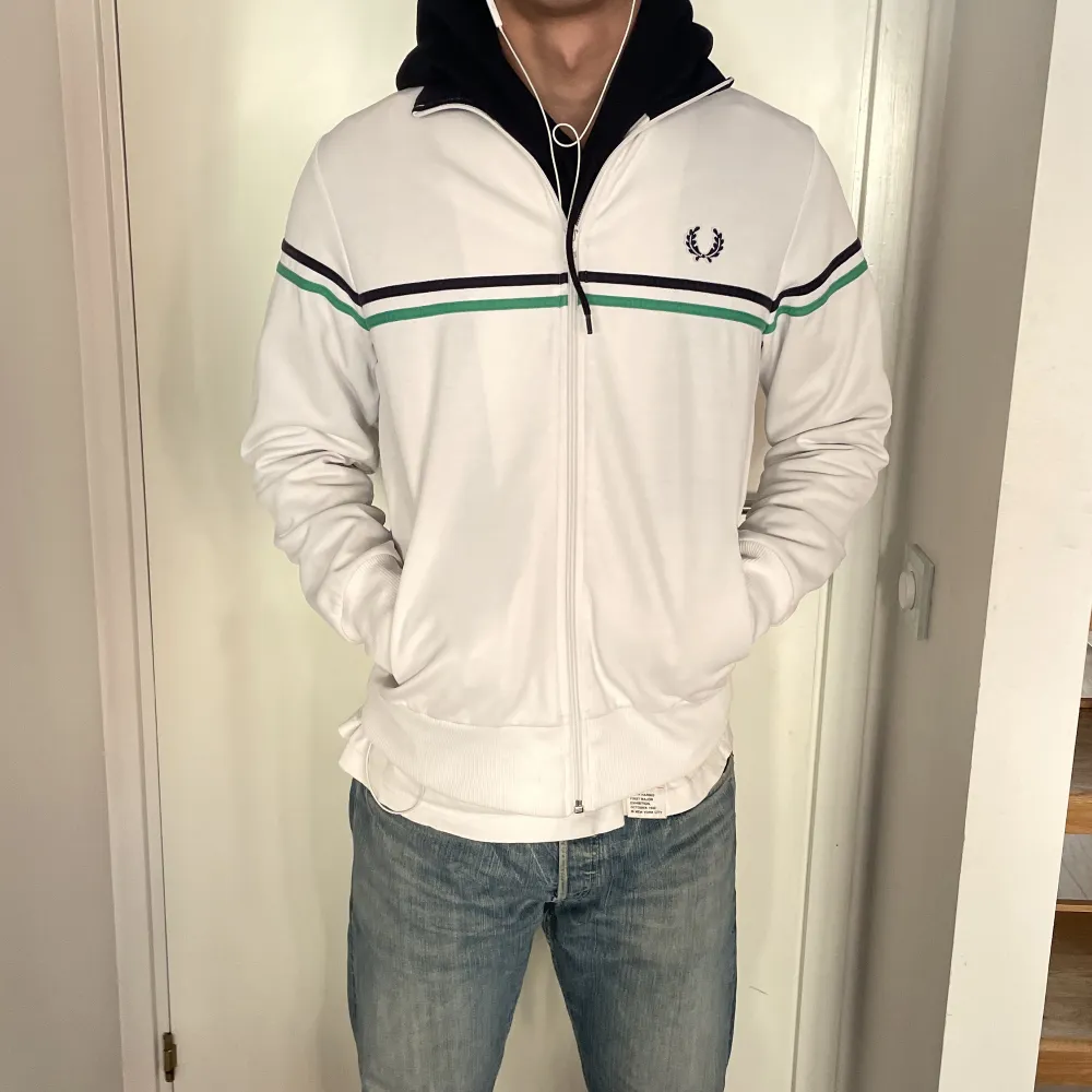 Zip up från fred perry i fräscht skick. Storlek M för killar och visas på en som är 184. Vit med blått och grönt streck samt blå krage. (På bilden har han en hoodie under). Hoodies.