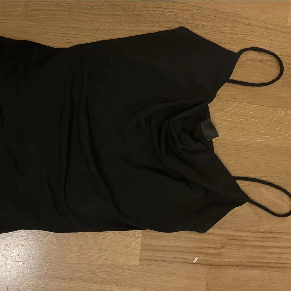 Säljer detta svart linne med en häng detalj där fram💗 säljer då den är för liten för mig . Toppar.
