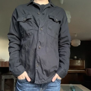 Overshirt (East west) - Riktigt fet overshirt inköpt på Brothers från märket East West, Modellen på bilden är ca 176 cm, Nypris= Ca 1000 kr  Mitt pris= 399 kr, Säljer då den sitter lite stort på mig 