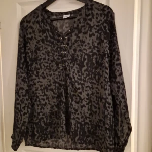 Spräcklig blus - Använd en gång så i nyskick, snörning framtill.