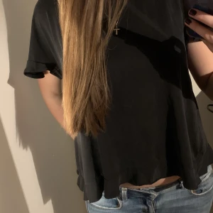 Topp - Söt t-shirt/topp me volang i ryggen och på armarna💞färgen är typ mörkblå/grå!