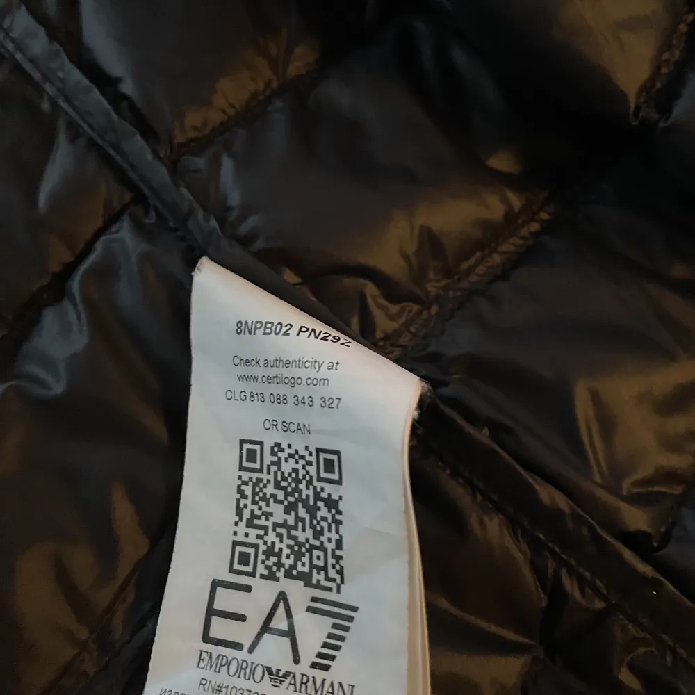 En svart dunjacka från EA7 med digitalt kvitto och QR-kod som autentisering (inköpt från Johnells).. Jackor.