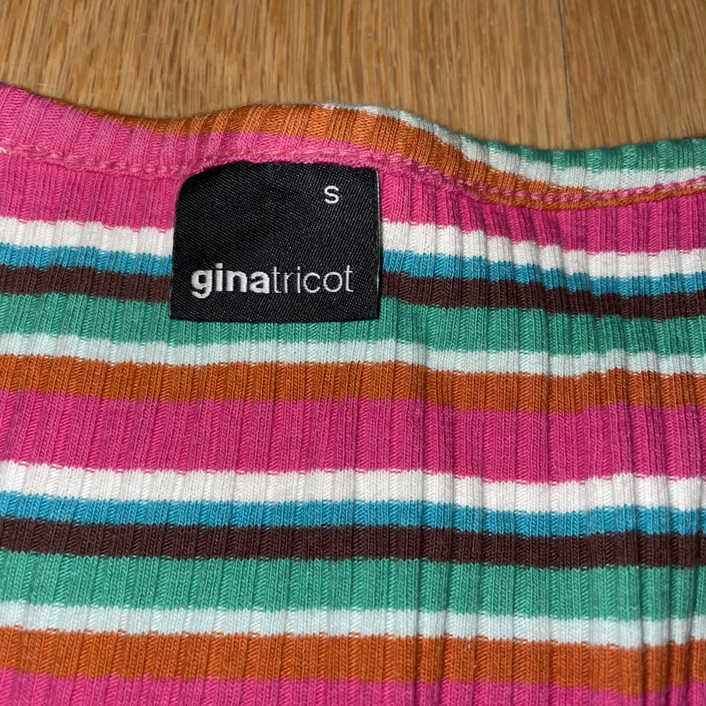 Regnbågig långärmad croppd tröja från Gina tricot. Väldigt bekvämt material med knapp detaljer. Mycket bra skick.. T-shirts.