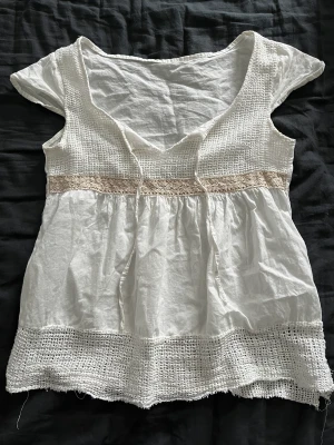 vit topp  - väldigt fin vit topp med guld detaljer som inte används🤍 står ingen kapp men uppskattar till S. väldigt fint skick förutom att lite av virkningen har spruckit på baksidan (bild 3) men knappast synligt. 