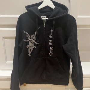 OneOfOne Zip Hoodie - Tjena! Säljer denna feta Zip hoodien från OneOfOne. Den är i toppskick utan defekter och köptes för några månader sedan. Alla stenar är kvar!🤩Nypris är 1500kr och mitt pris är 400kr!💥Storlek S, svart. Hör av er i DM för eventuella frågor. 