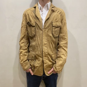 Safari Jacka Gsus - Hej! Säljer nu min jacka från märket Gsus storlek M i fint skick. Modellen på bilden är 180cm lång och väger 80kg. Tveka inte på att höra av dig om du har några frågor eller funderingar kring varan!