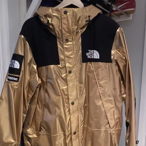 supreme TNF metallic mountain parka gold - Säljer nu min Supreme TNF parka. Den är sparsamt använd. Säljer den pga att jag inte använder den längre. 
