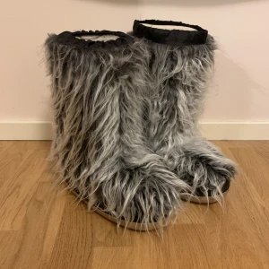 fluffiga vinterskor - Fluffiga ”moon-boots”, jätte varma och knappt använda, den enda defekten är att kanten på den vänstra skon har gått upp, detta är inget som syns när man har på sig skon och det går jätte lätt att lösa med lätta sykunskaper!  Hör av dig vid mer frågor💗💗