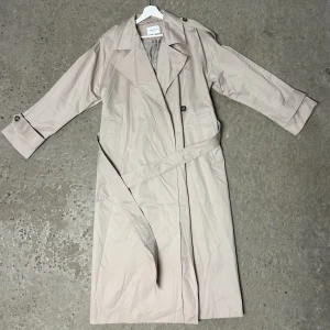 Trenchcoat  - Säljer min sparsamt använda trenchcoat från Stockh lm Studio. Storlek S men passar S/M. Slutsåld överallt och nypris ligger på 1699kr. 