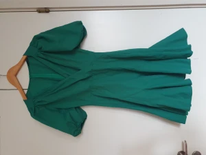 Fin oanvänd klänning - En grön klänning med puffärmar och blixtlås där bak. Den är aldrig använd. Den var inte min stil. 