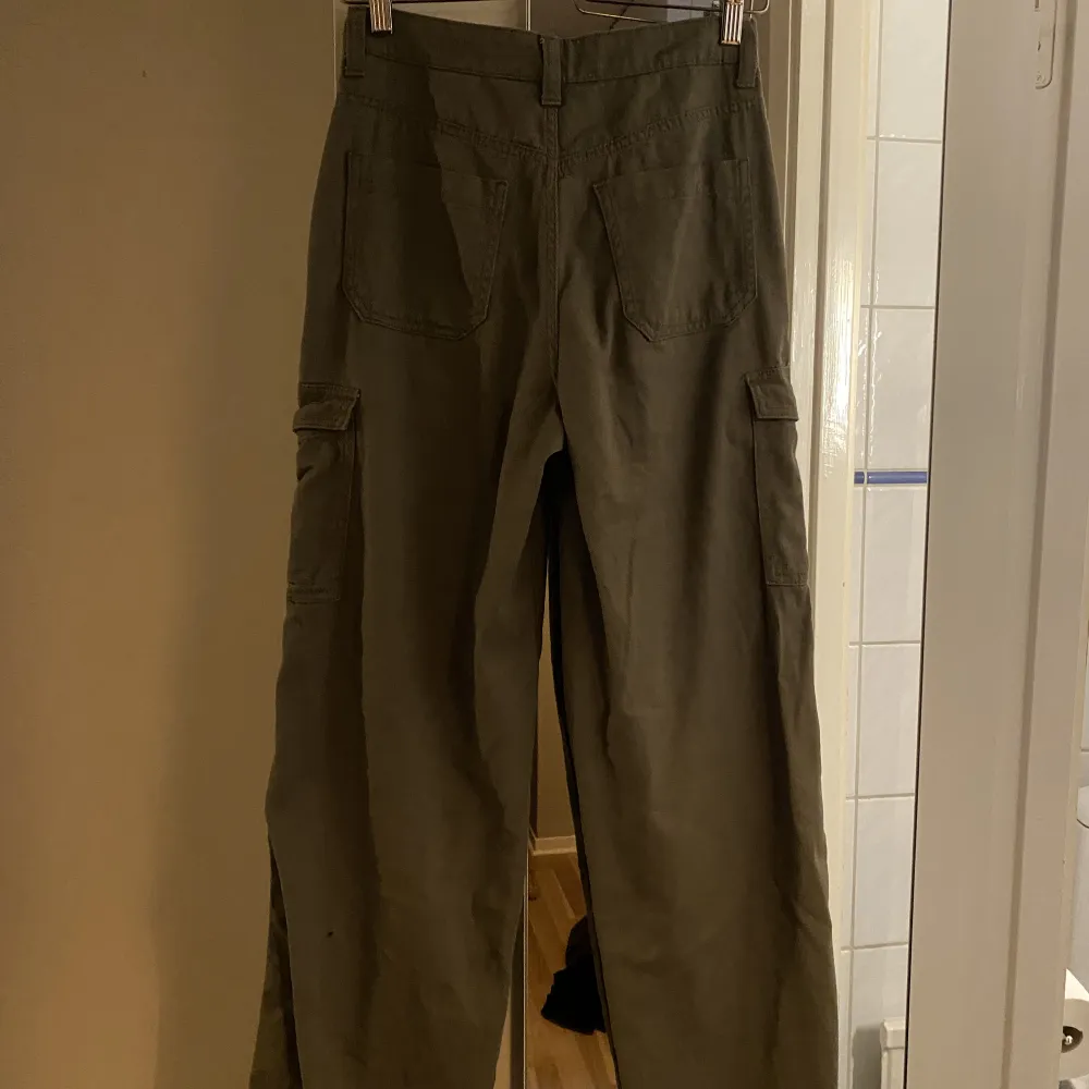 Riktigt snygga khakigröna cargopants från H&M. Endast använda vid två tillfällen. Storlek 34, de är oversized i modellen så går att ha som low waist. Jag är 163 cm lång. . Jeans & Byxor.