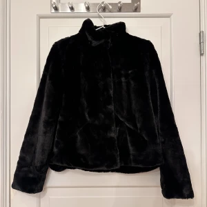 Svart jacka i fuskpäls - Svart jacka i fuskpäls från Only, storlek S. Knäpps med knappar. Fickor på sidorna. Jättemjuk och gosig. Aldrig använd. 