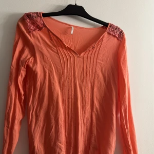 Blus  - Den är mycket mer rosa i verkligheten , titta bild 2. Det står ingen storlek men den passar xs-m 