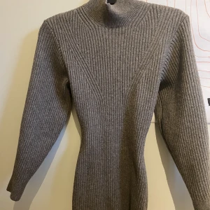 Figursydd stickad klänning från H&M - En figursydd stickad och varm klänning från H&M som enbart använts en gång. I superbra skick och fin kvalitet :-) (Sista bilden är lånad från H&M i annan färg). Slutar någon decimeter ovanför knäna på mig som är 1.64.