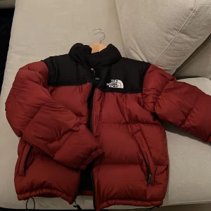 North Face Nuptse Jacka - Nuptse jacka i väldigt bra skick! Ett mindre märke på ena sidan av axeln men annars ingen täcken på användning alls. Köpt för 3699, storlek M. 