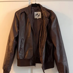 Läderjacka - Vinröd/ Brun färg typ. Storlek S skulle jag säga. Sitter på bältet på mig som är 175. Hör av er om ni har några frågor eller funderingar. Den är i väldigt bra kvalitet   Har en massa kläder både för tjejer å killar på min sida. Jag kan lösa paketdeals :)