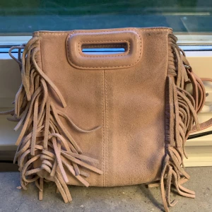 Maje Väska - Liten ljusrosa handväska från Maje. Sliten och använd, det går säkert att göra den finare med lite tvätt eller om man lämnar in hos kemtvätt. 