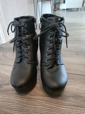 Högklackade skor  - Använda men i bra skick, några slitningar (se bilder). Knäpps med dragkedja på insidan.  Klackhöjd 11,5 cm. Platå på 3 cm, vilket gör att dom är bekväma och enkla att gå i.