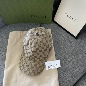 Gucci keps beige med box  - Mycket fin stilren Gucci keps av färgen beige med prislapp och boxen med samt dustbag. Hör av dig vid intresse!