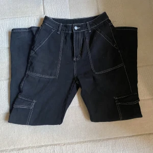 Svarta cargojeans  - Svarta cargojeans från SHEIN. Högmidjade, 35cm tvärs över. Passar bra i längden på mig som är 162.