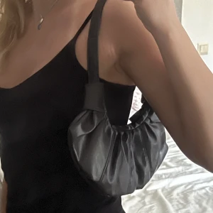 Liten mörkbrun väska - Supersöt liten mörkbrun väska med knytdetaljer och dragkedja. Passar perfekt till dagar då man behöver en mindre väska. Inga defekter! 🫶💕