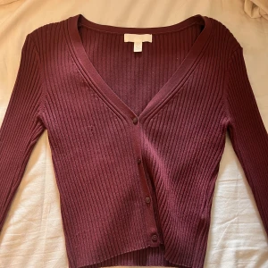 V-ringad topp - Ribbad vinröd långärmad topp. Knappt använd med 70% viskos så den är jätteskön. För mig som är 177 slutar den lite efter naveln. 