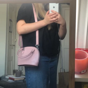 Väska - Väska från Asos design. Remmen är avtagbar, köptes för 100kr säljs för 40kr. Helt ny, aldrig använd. Frakt beroende på hur köparen vill att den ska skickas.