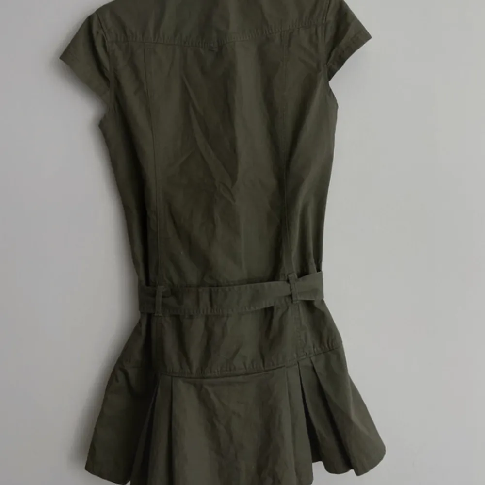 Säljer denna ursnygga olivgröna militärinspirerade klänningen med så snygga detaljer!!💖 Den passar mig som är S/M men går att justera i midjan med ett midjeband så passar nog de flesta!! Jag är 175 och den är bra i längden, men passar också korta!🌸💓. Klänningar.