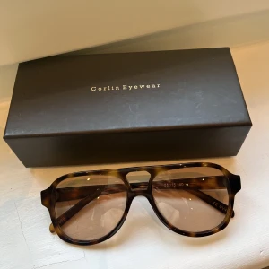 Solglasögon Corlin Eyewear - Säljer dessa fina glasögon från Corlin Eyewear i modellen Gelo Cinnamon.  De är i bra skick och har inga synliga repor. Box finns.  Nypris 1200kr. 