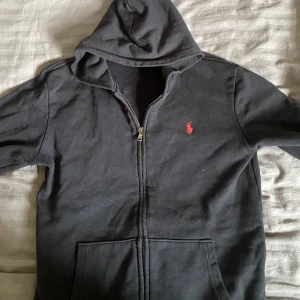 Ralph loren hoodie - Använd några gånger men inga skador på den. Jag har tagit bort snöret men självklart kommer det med. Dragkedjan  fungerad felfritt men för något tag sen blev den lite krånglig men går att knäppa oftast. Fixats lätt genom att byta knäppet.
