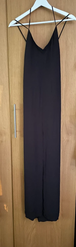 Klänning - Supersnygg svart klänning från & Other stories, stl 36. Reglerbara axelband som är korsade i ryggen. Sprund fram. Aldrig använd.