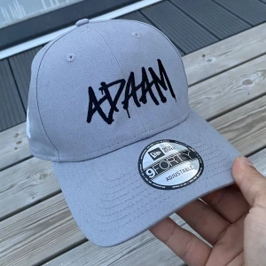 Keps buren av ADAAM på scen  - Kepsen ADAAM hade på sig under Karlskronas skärgårdsfestival sommaren 2022 som han senare kastade ut i publiken! 