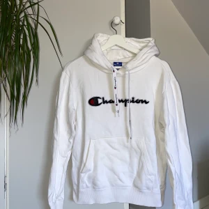 Champion hoodie  - Vit hoodie från champion i storlek M. Använd men i gott skick utöver en liten fläck vid ena armen, se bild. 