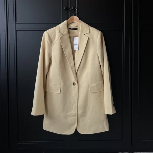 Gul kavaj  - Gul kavaj från Gina Tricot. Prislapp kvar.  Storlek: S  Pris: 400 kr ink frakt Material: 100% Polyester  Skick: Inga anmärkningar. Oanvänd. 