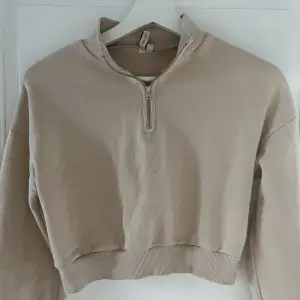 En beige sweatshirt med dragkedja, kortare i modellen!🤍 aldrig använd 