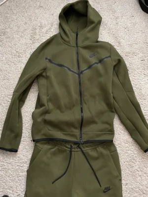 Nike tech  - Hej säljer denna då jag inte gillar längre den typ av stil, allting e bra på den det är ba kedjan som man kan se på bilderna och gått i sönder lite pågrund av tvätt maskinen, det är en storlek S. men annars är den hur bra som helst inget fel alls med den.