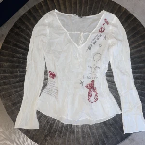 Fin topp m. vit röda detaljer  - En vit topp med vita och röda insydda texter och figurer💕 pris kan diskuteras 