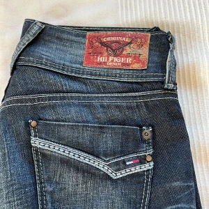 Tommy Jeans  - Säljer dessa skit snygga lågmidjade Tommy Hilfiger jeans. Köpta från plick men säljer då de tyvärr inte passade. 39cm i midjan rakt över och 81cm innerbenslängden. Fint skick, inga defekter. Pris kan diskuteras💕