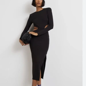 Midiklänning - Midiklänning med slits, cutout och axelvaddar.   Aldrig använd, prislappen finns kvar.