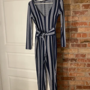 Bershka dress  - En mörk blå och vit byxdress med två band i höften som man kan spänna, inga skavanker. Väldigt fin.