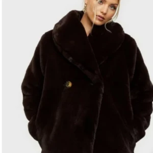 Dry Lakes mjuka faux fur, mörkbrun S, helt ny. - Helt underbart mjuk,ny  mörkbrun fuskpäls från Dry Lake med stor, gosig sjalkrage. Tillfälle att få en varm och skön vinterkappa. Ny, aldrig använd. Skickas gärna spårbart Postnord mot fraktkostnad.