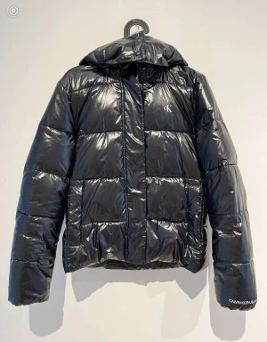 Calvin Klein jeans - HIGH SHINE PUFFER - vinterjacka - Jag säljer nu denna snygga vinterjacka som jag köpte ny förra året. Den är väl omhändertagen och ser iprincip ut som ny, liten defekt se bild 2.  Säljer då jag köpt en ny. Nypris: 2195kr