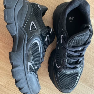 Svarta sneakers med reflex detaljer  - Nyskick, ej använda endast provade inomhus. Storlek 37, säljer då dem är lite för små för mig. Från h&m , nypris 500kr